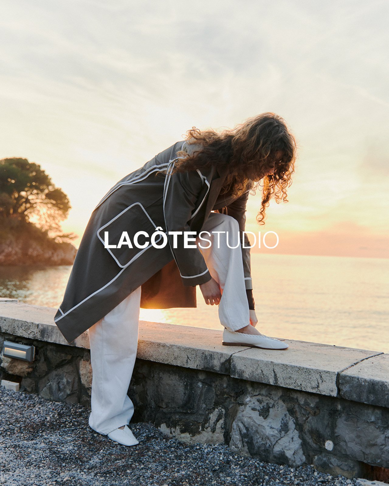 LA CÔTE — campaign, fastening a shoe on a seaside wall at sunset